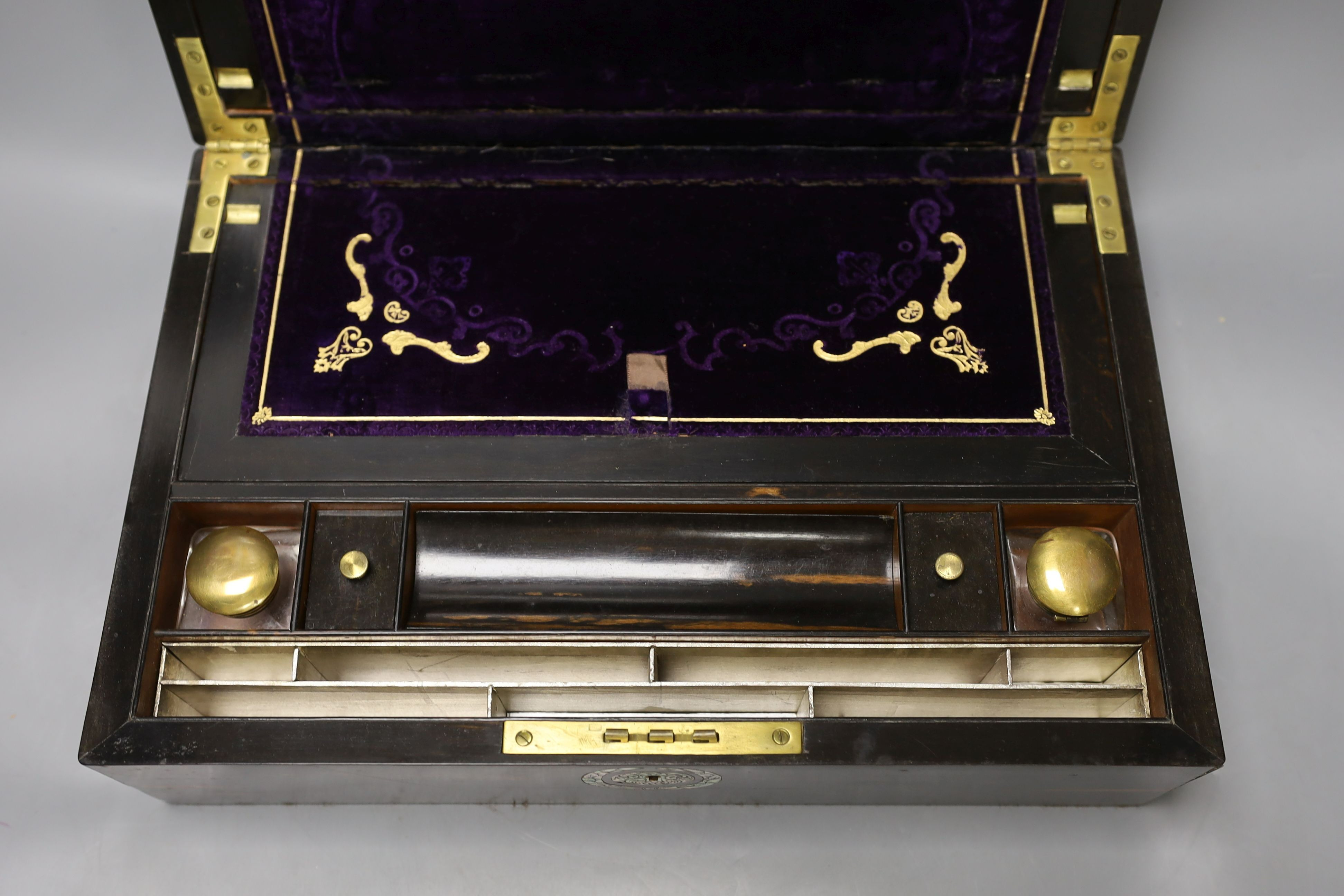 A 19th century coromandel wood writing slope with mother-of-pearl cartouche and original purple tooled velvet interior, 38 cms wide by 25 cms deep.